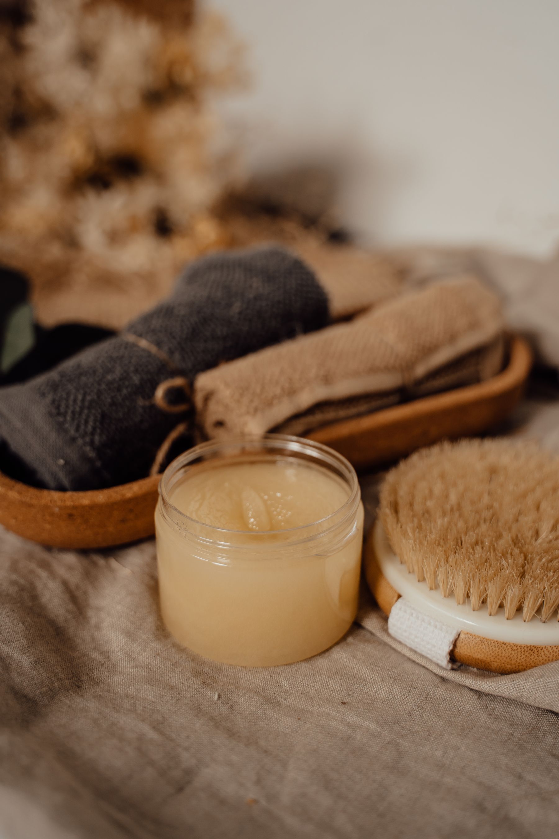 Natural body scrub, brush and towels arranged for an exfoliating treatment