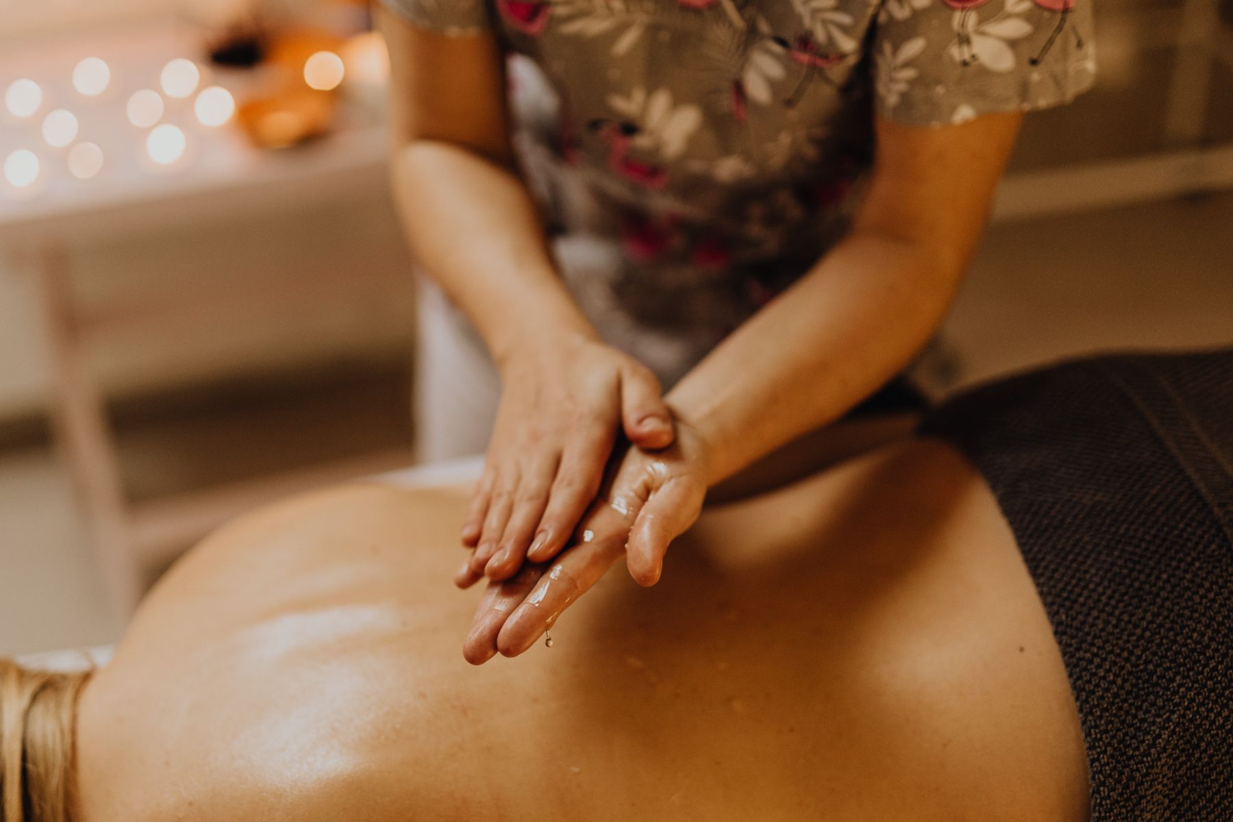 Therapist applying massage oil during a calming back treatment